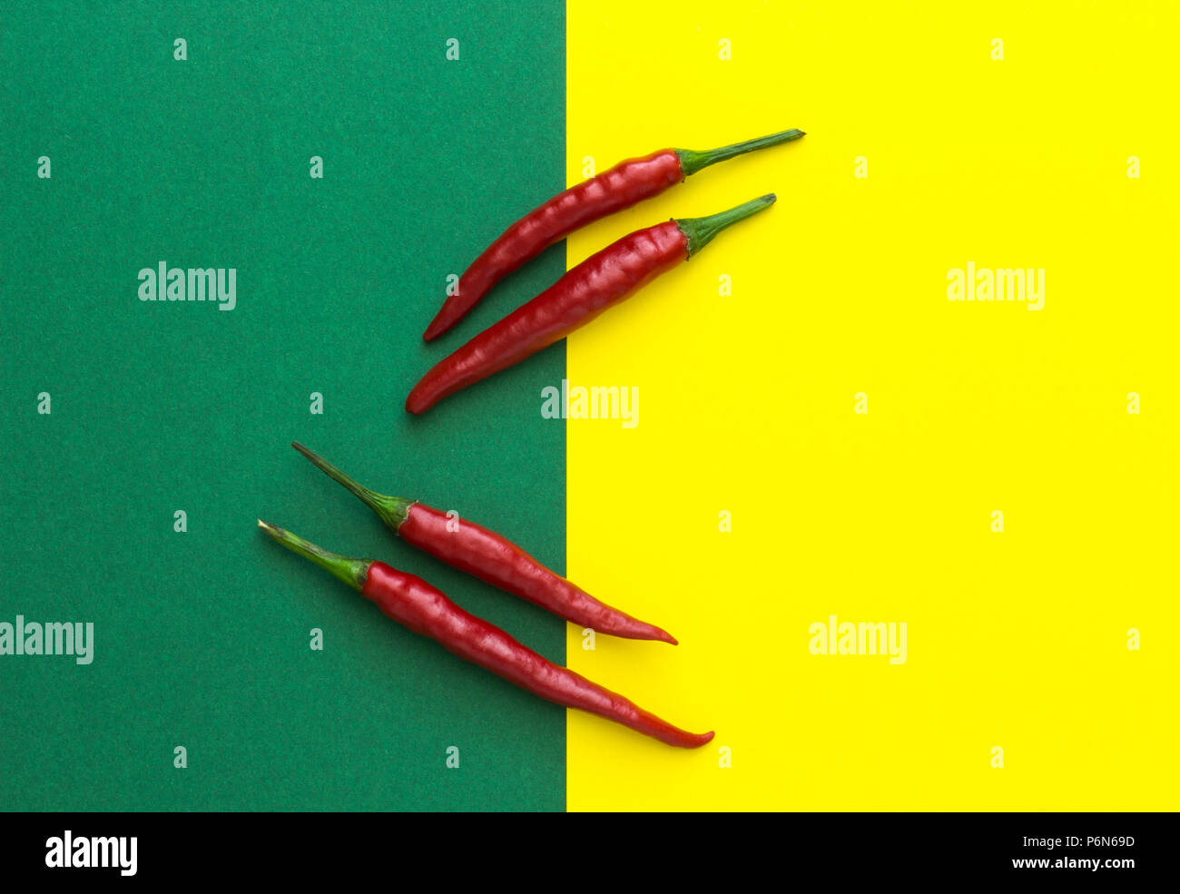 top view, four red chili peppers on a yellow-green background Stock ...