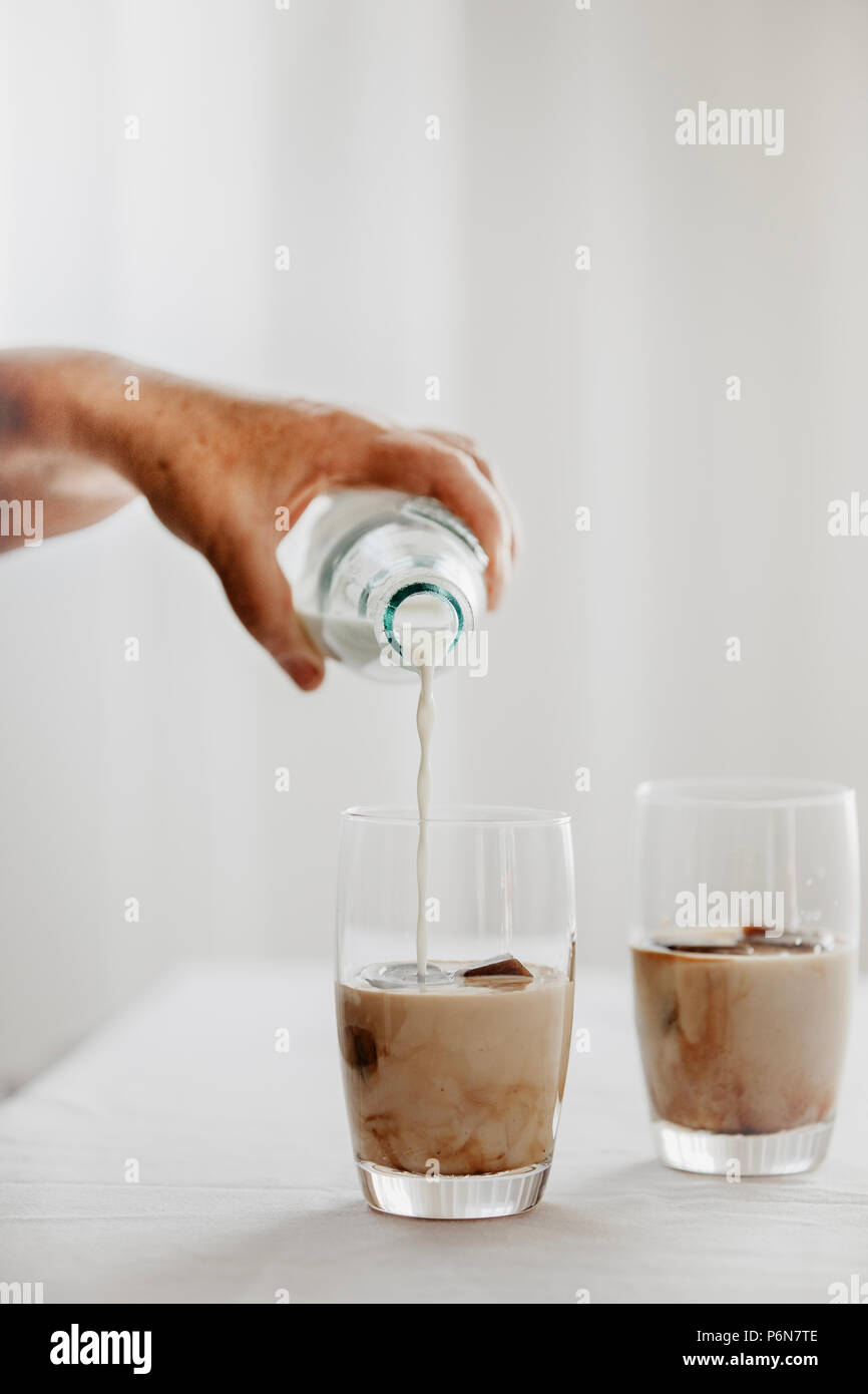 Frozen coffee ice cubes in a glass poured with milk to make a