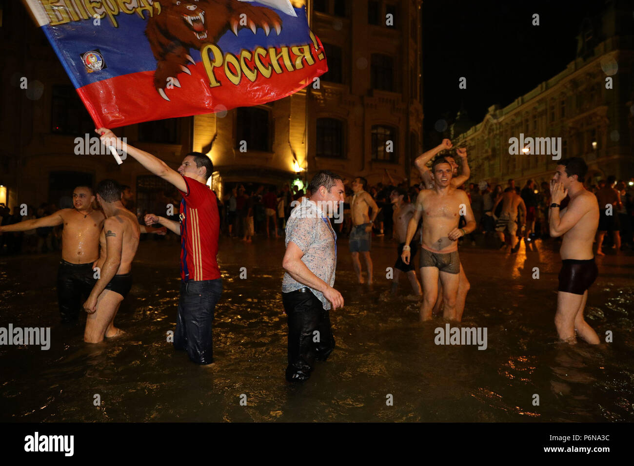 Carnival atmosphere as Russian fans in a fountain near Red Square, Moscow celebrate their victory over Spain in the last 16 at the 2018 FIFA World Cup in, Russia. Stock Photo