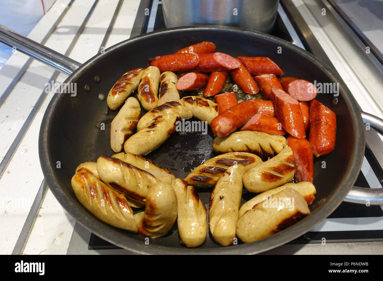 Austro-Bavarian sausages sizzling on the stove Stock Photo