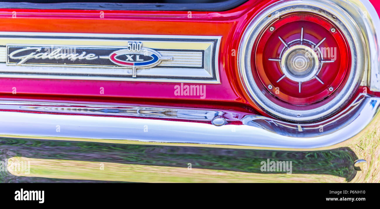 Shallow depth of field closeup of the taillight assembly and rear nameplate on a 1964 Ford Galaxie 500 XL convertible. Stock Photo