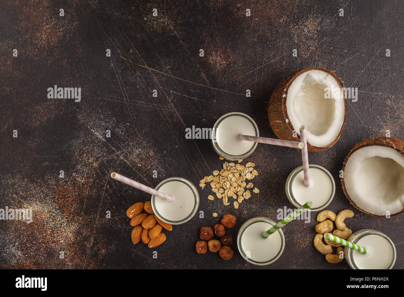 Vegan alternative nut milk in glass bottles on a dark background, copy space. Healthy vegan food concept. Stock Photo