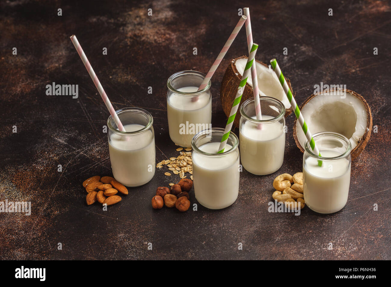 Vegan alternative nut milk in glass bottles on dark background. Healthy food background. Healthy vegan food concept. Stock Photo