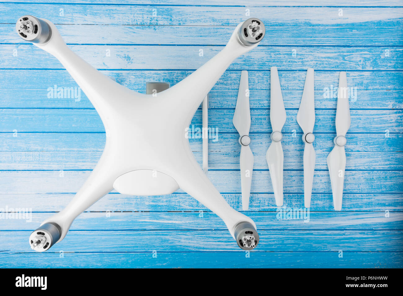 Modern High Tech Big White Drone With Propellers Detached On Blue And White Painted Wood Background Quadcopter Concept Top Angle Stock Photo