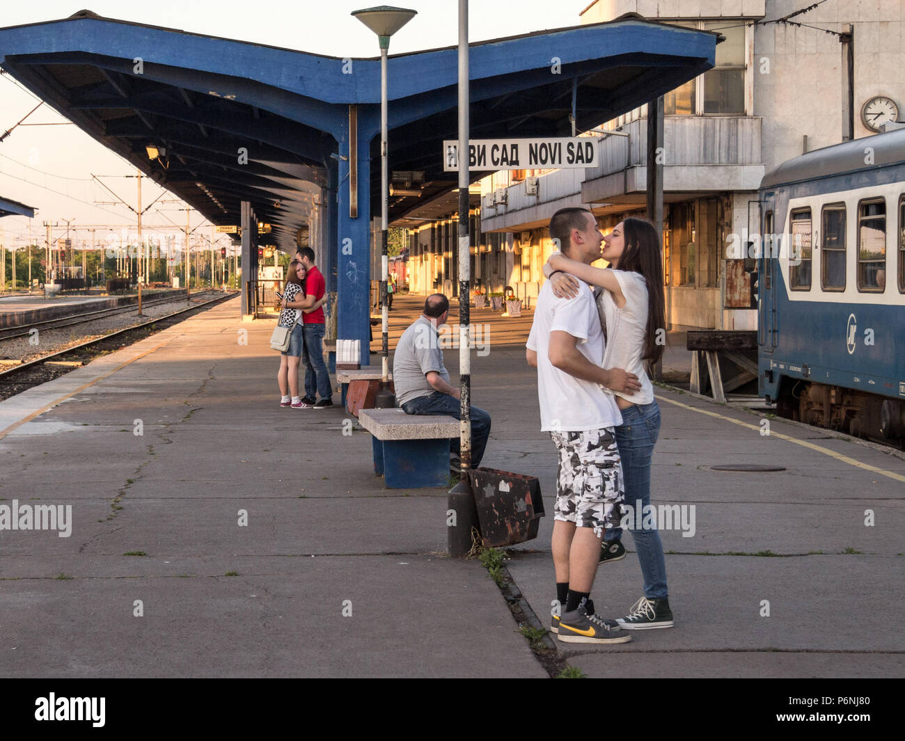 NOVI SAD, SERBIA - MAY 30, 2015, 2015: Two couples of white caucasian male and females kissing in Novi Sad train station waiting for the train that wi Stock Photo