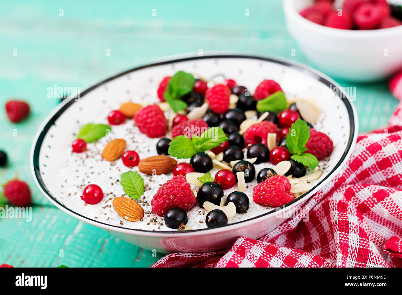 Detox and healthy superfoods breakfast in bowl. Vegan almond milk chia seeds pudding with raspberries, blackberries and  mint. Stock Photo