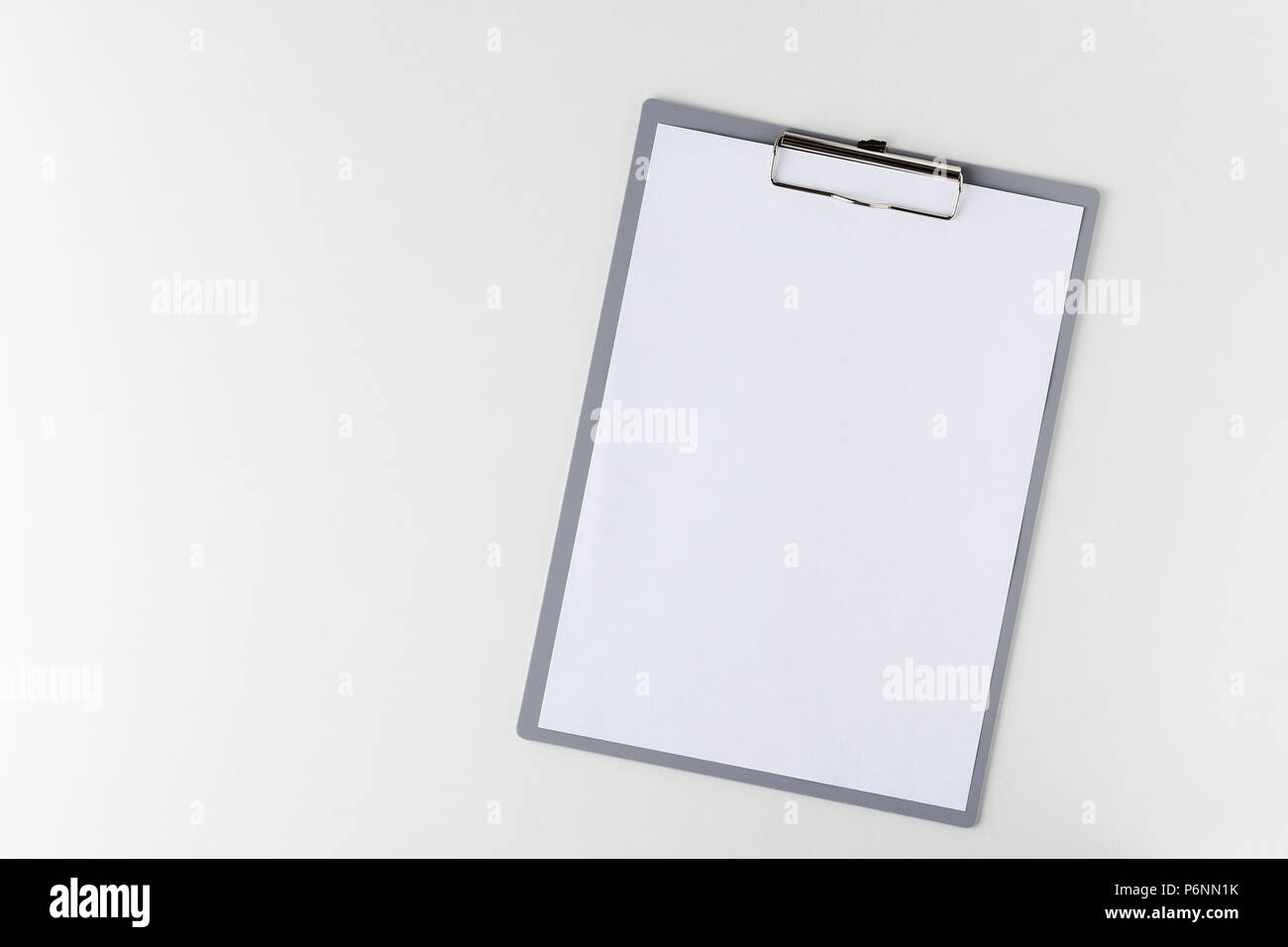 clipboard with a blank sheet of paper on a light background with