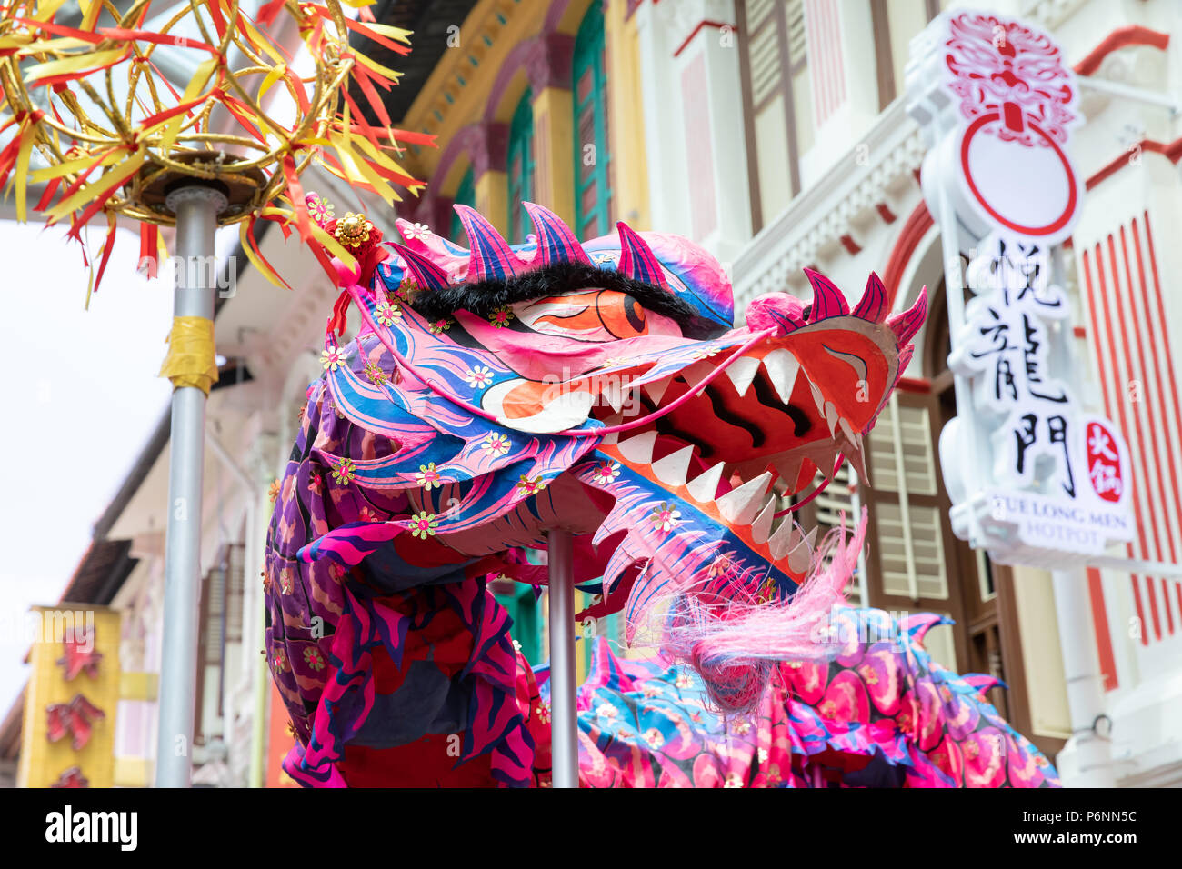 Singapore - Jun23, 2018: Colorful and symbolic Chinese dragon dance on the streets of Singapore Chinatown on the occasion of the opening of a new rest Stock Photo