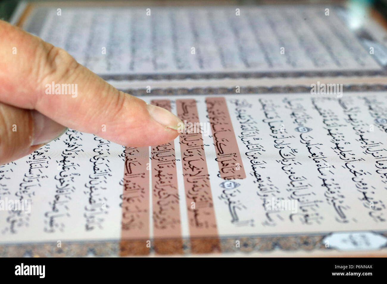 Man reading an electronic Quran on a tablet. Stock Photo