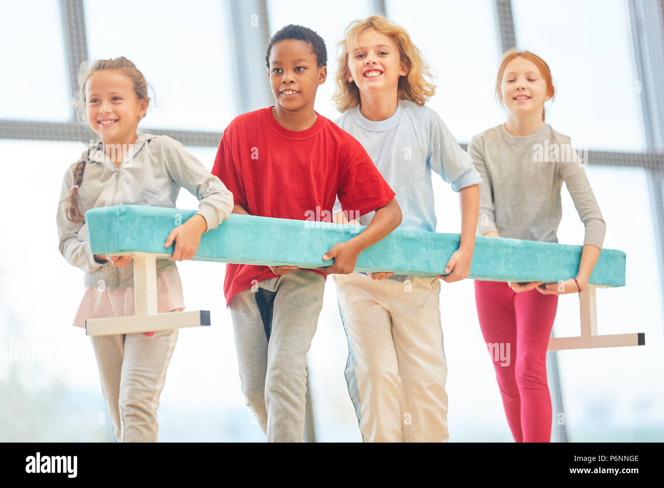 Group of students together carry a balance beam in physical education class Stock Photo