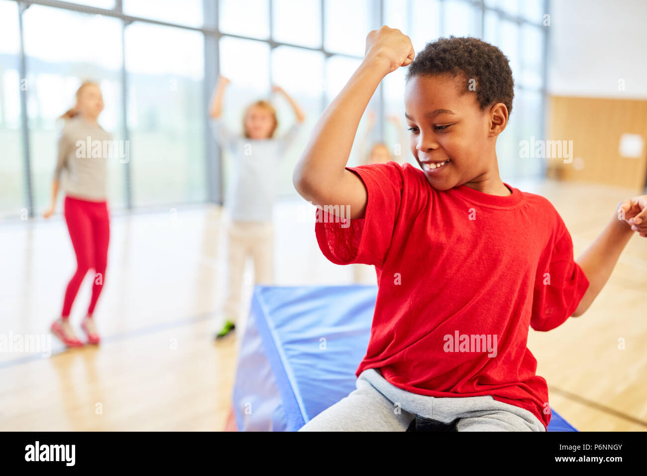 Sporty boy shows his muscles in elementary school physical education Stock Photo
