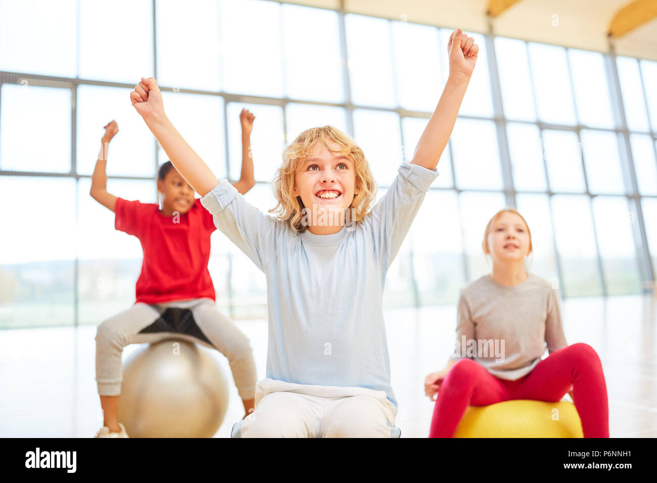 Group of children cheers as a winner in a competition in physical education Stock Photo
