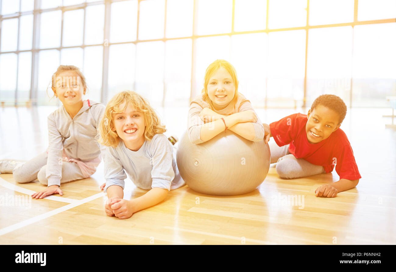 Happy group of kids with ball in elementary school physical education Stock Photo