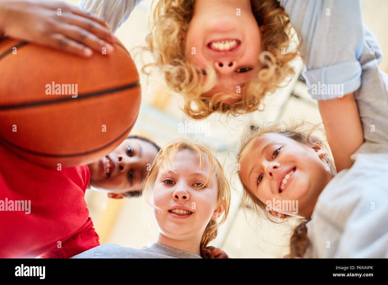 Group of happy kids makes a basketball team at school Stock Photo