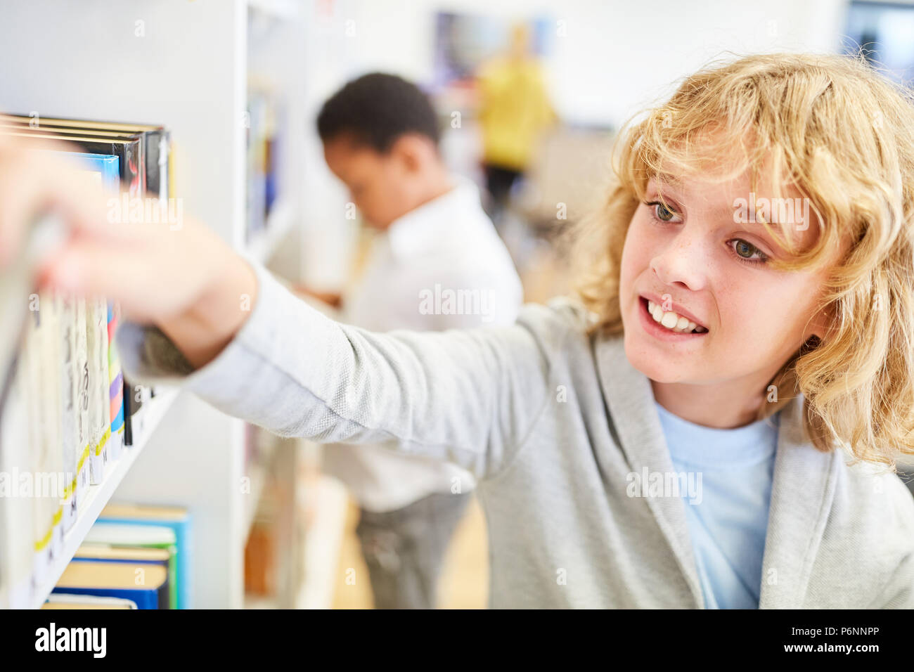 Two students in the school's library borrow books to study Stock Photo