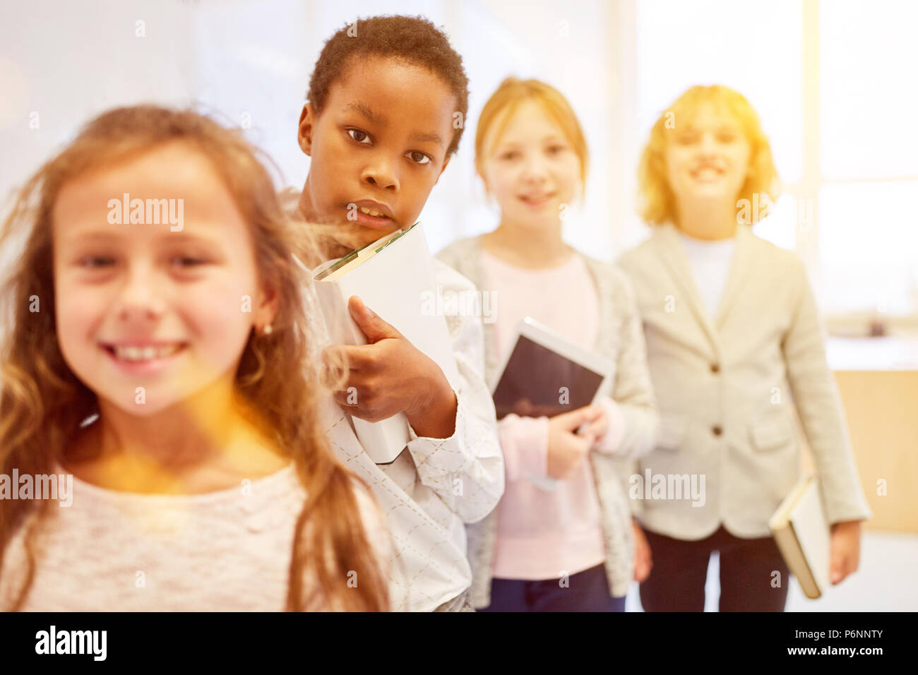 Group of pupils with book and tablet computer in elementary school Stock Photo