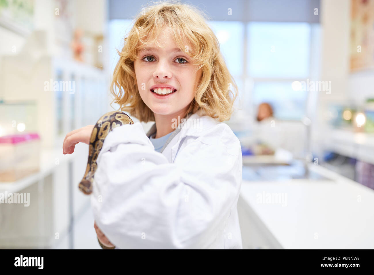 Boy provides exotic snake in a primary school biology experiment Stock Photo