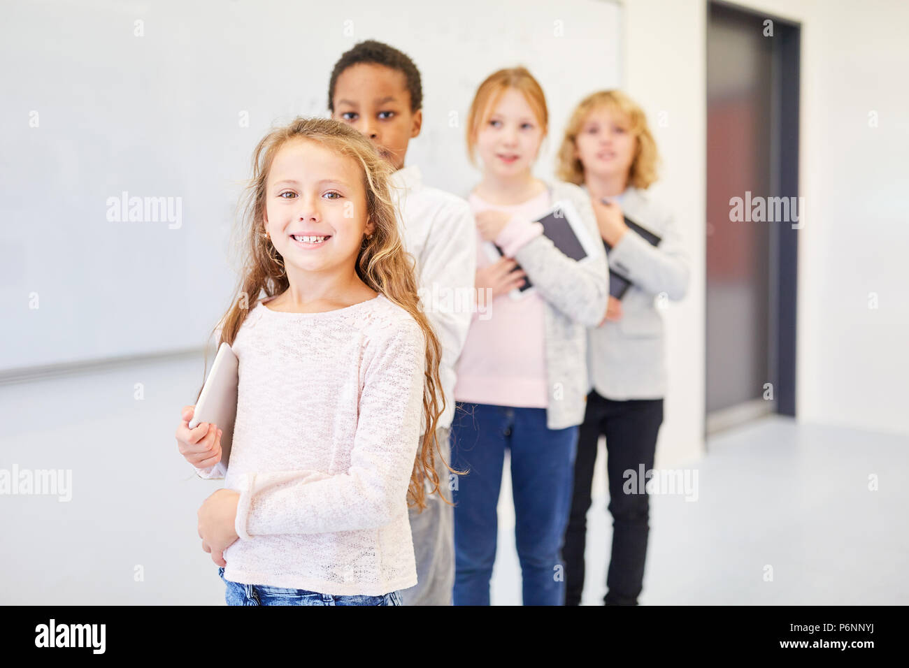 Group of kids as elementary school students learn mobile with tablet computer Stock Photo