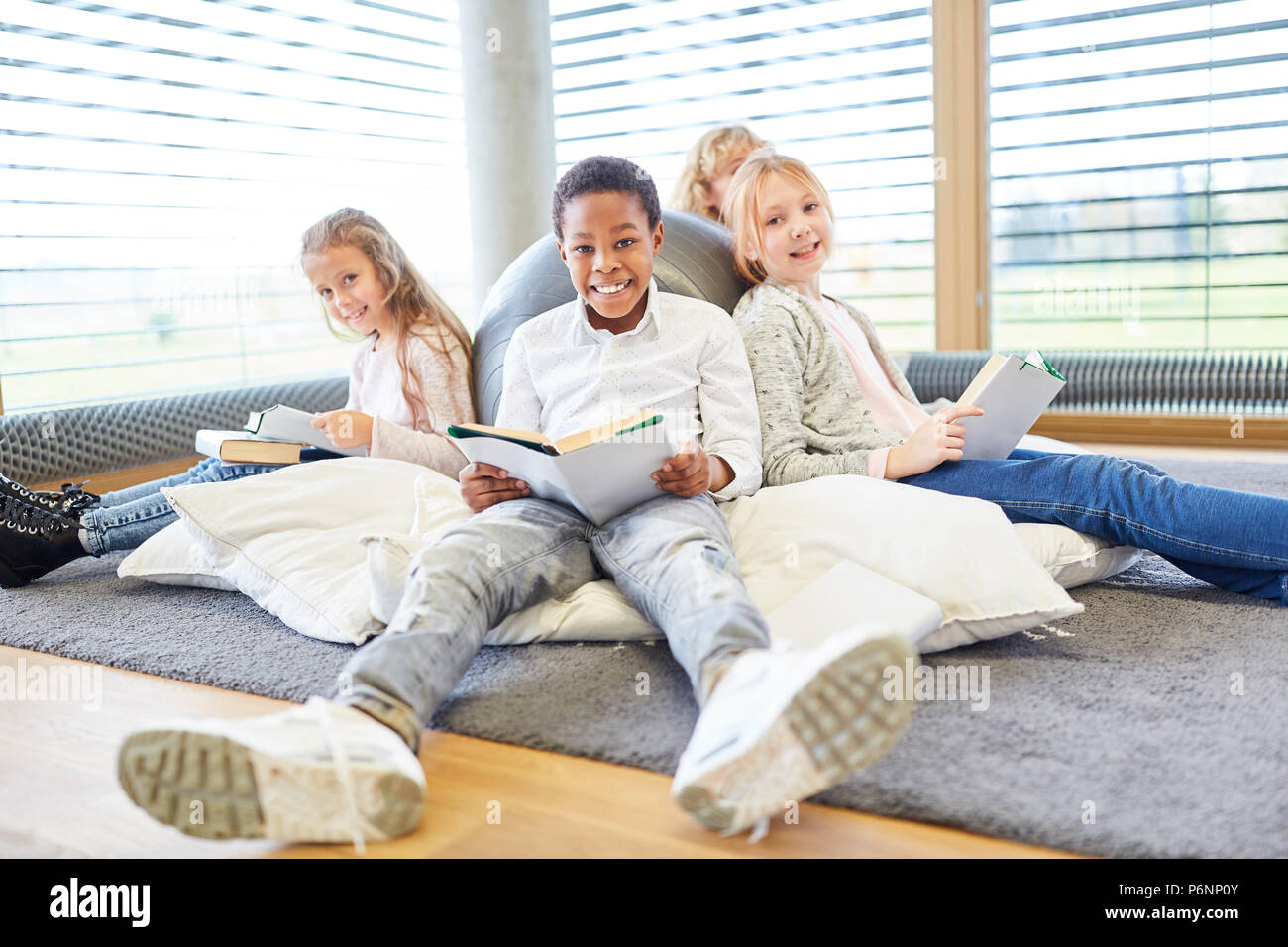 Group of kids of elementary school while reading relaxed in free time Stock Photo