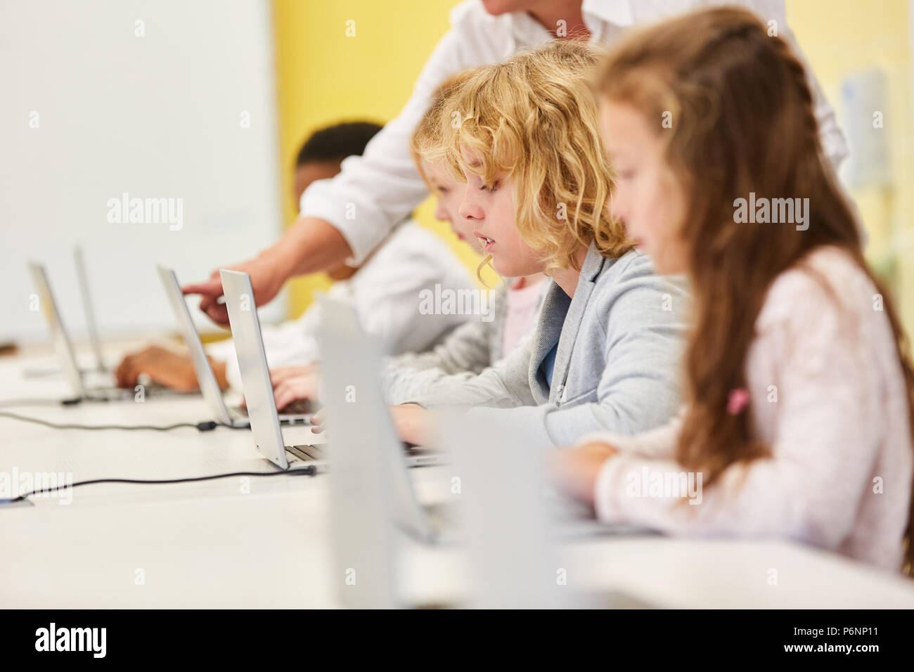 Children learn together Computer science in the computer. Elementary school lessons Stock Photo