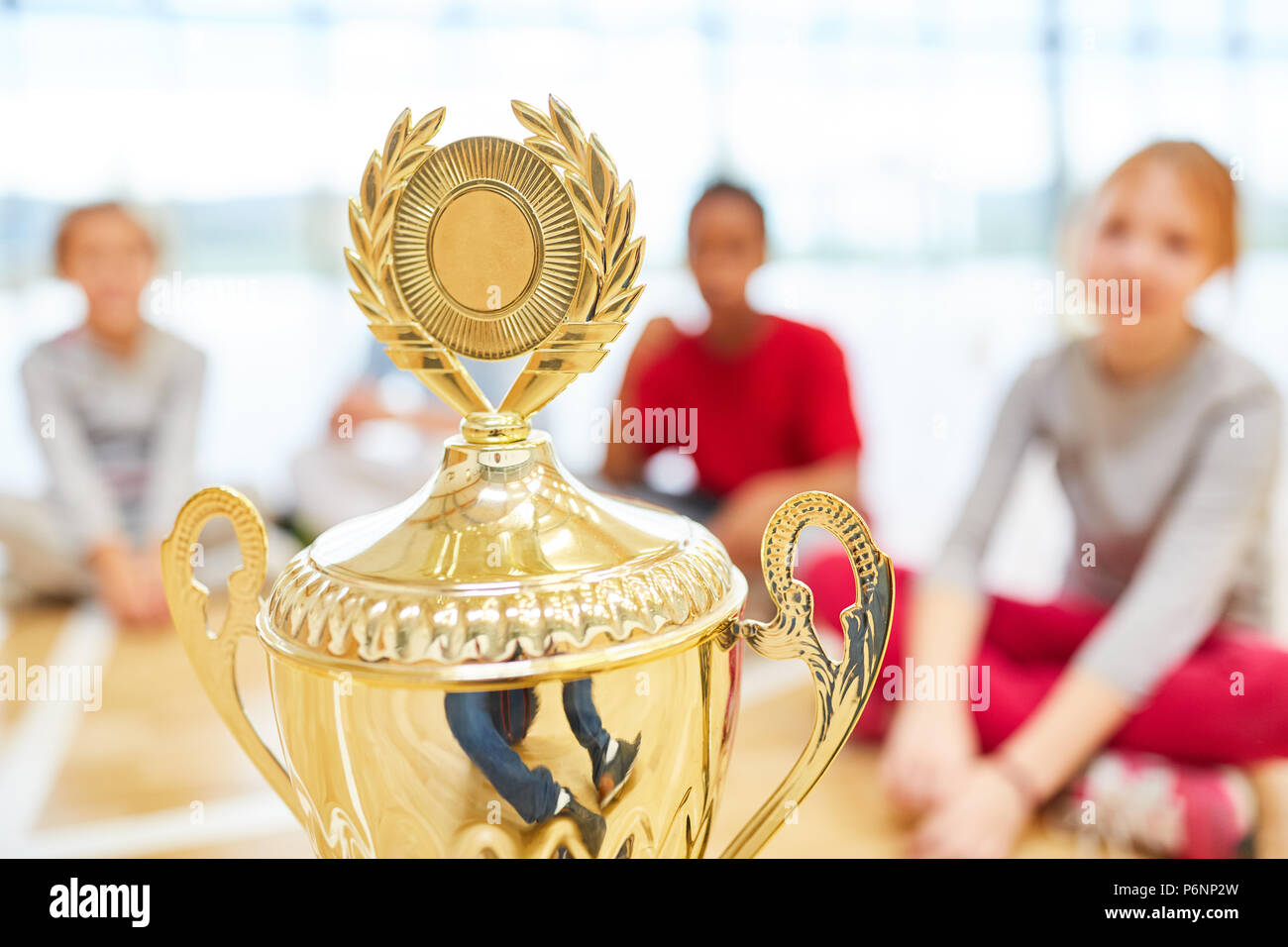 Winners cup at a competition in school sports with children in the background Stock Photo