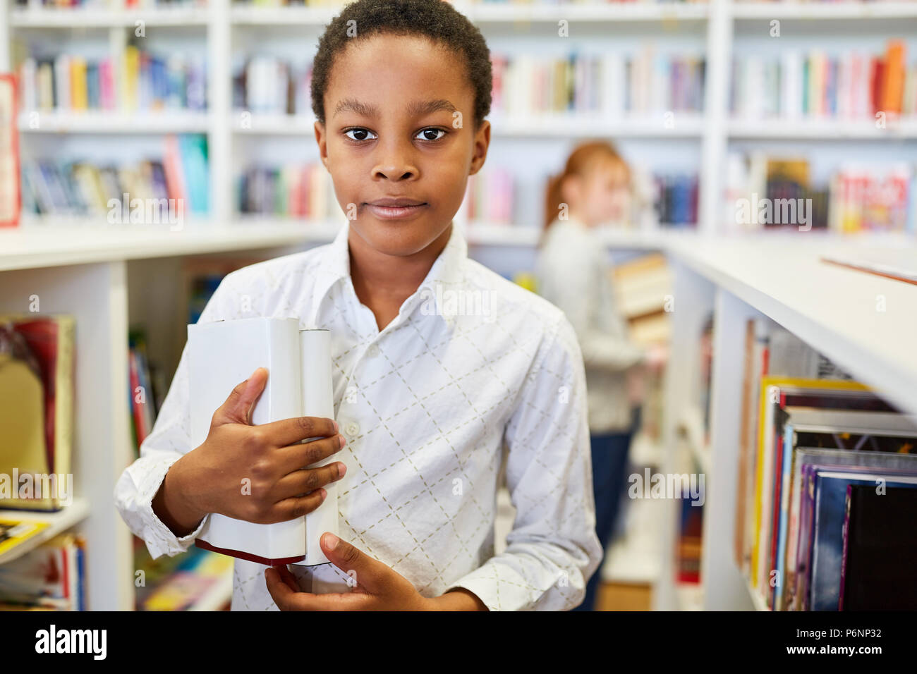 African student borrowing books from the school library Stock Photo