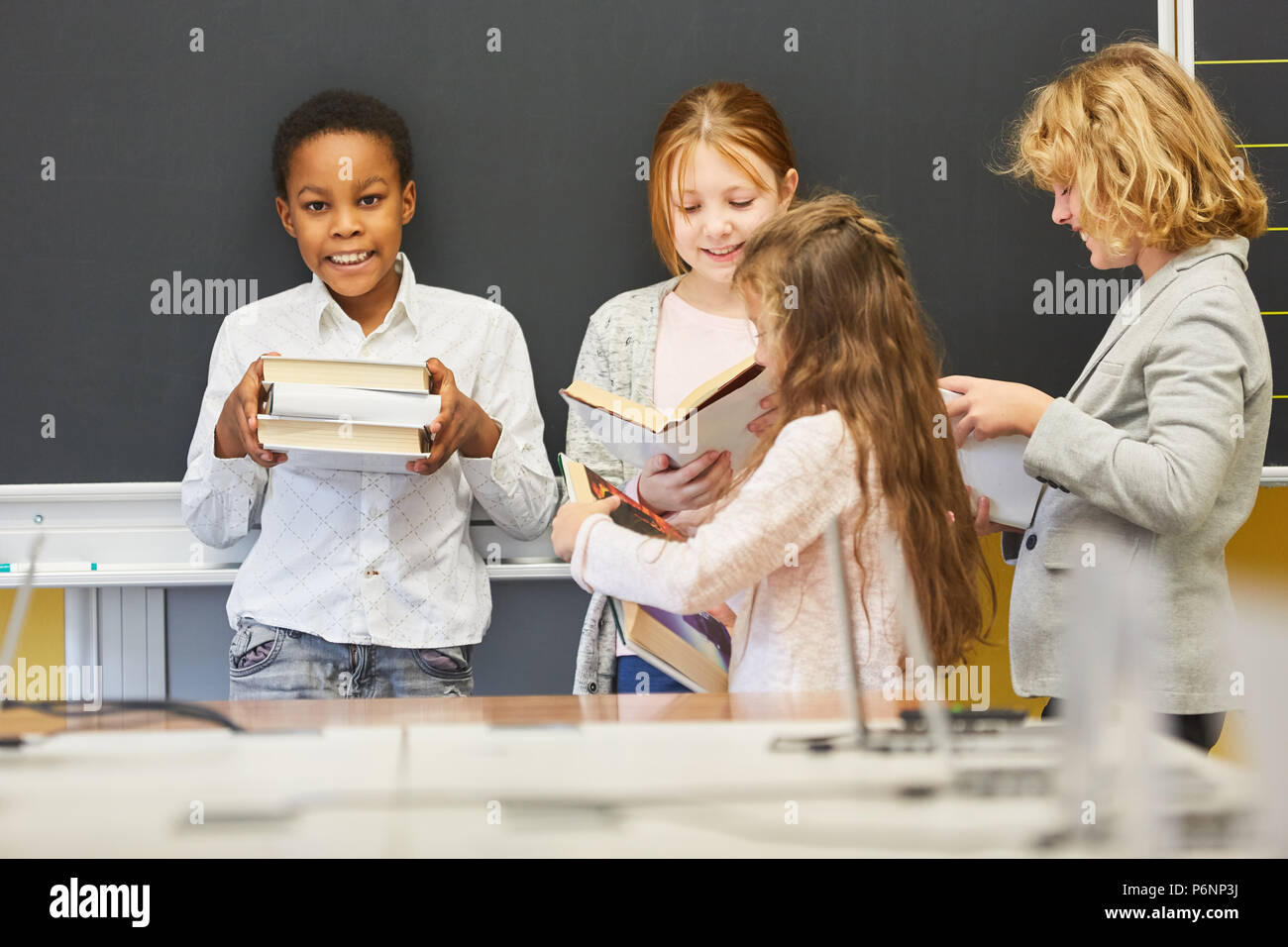 Children of elementary school with books while reading together in a study group Stock Photo