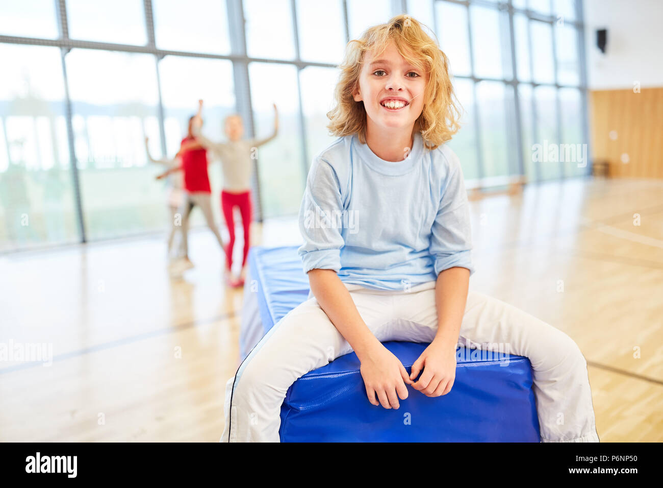 Happy boy in sports class in a primary school gym Stock Photo