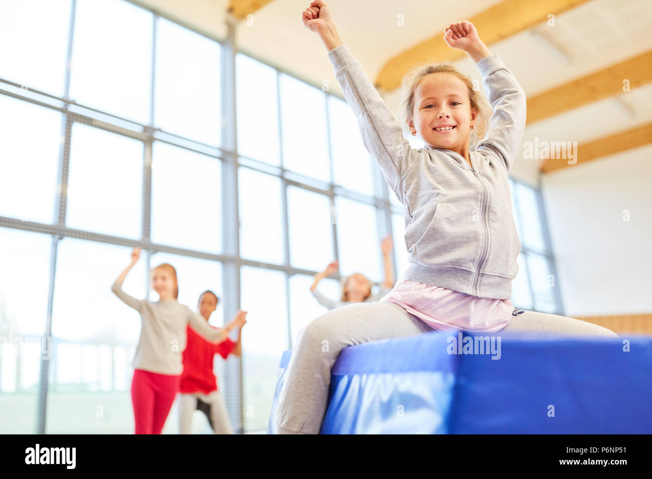 Girls in elementary school physical education are having fun doing gymnastics Stock Photo