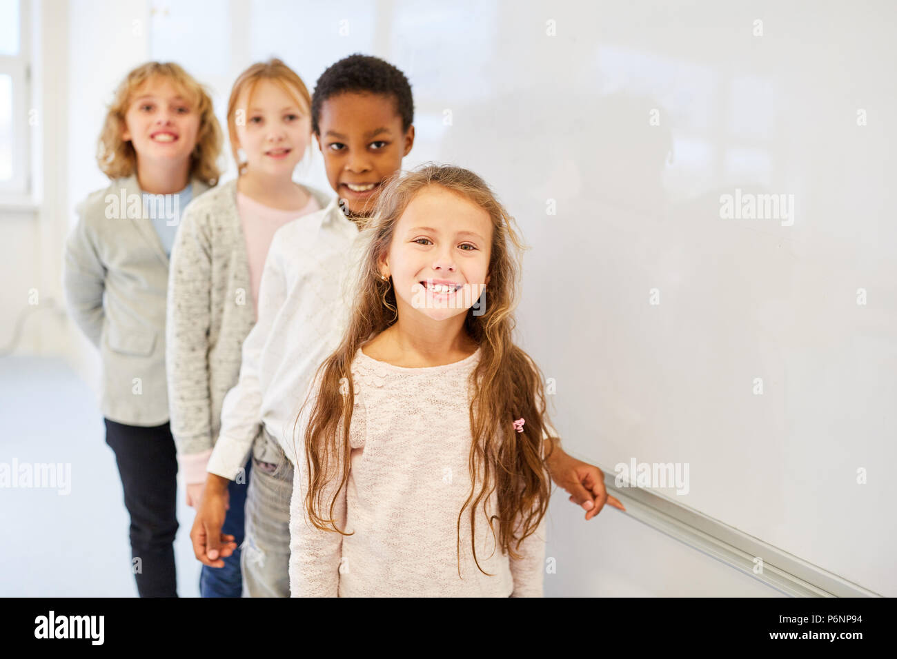Four happy kids in a multicultural elementary school as friends Stock Photo
