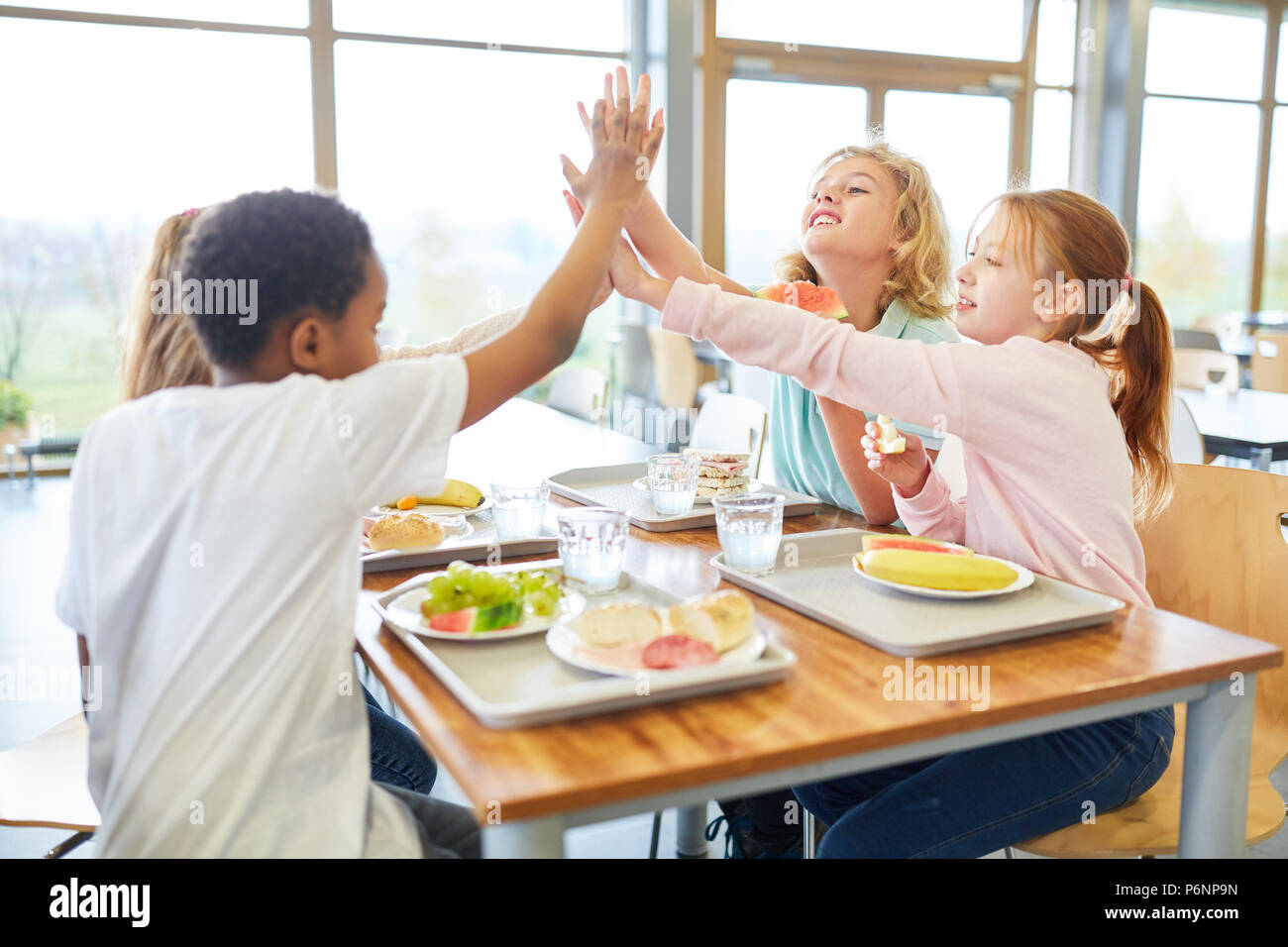 Happy kids have fun together in the canteen of the elementary school Stock Photo