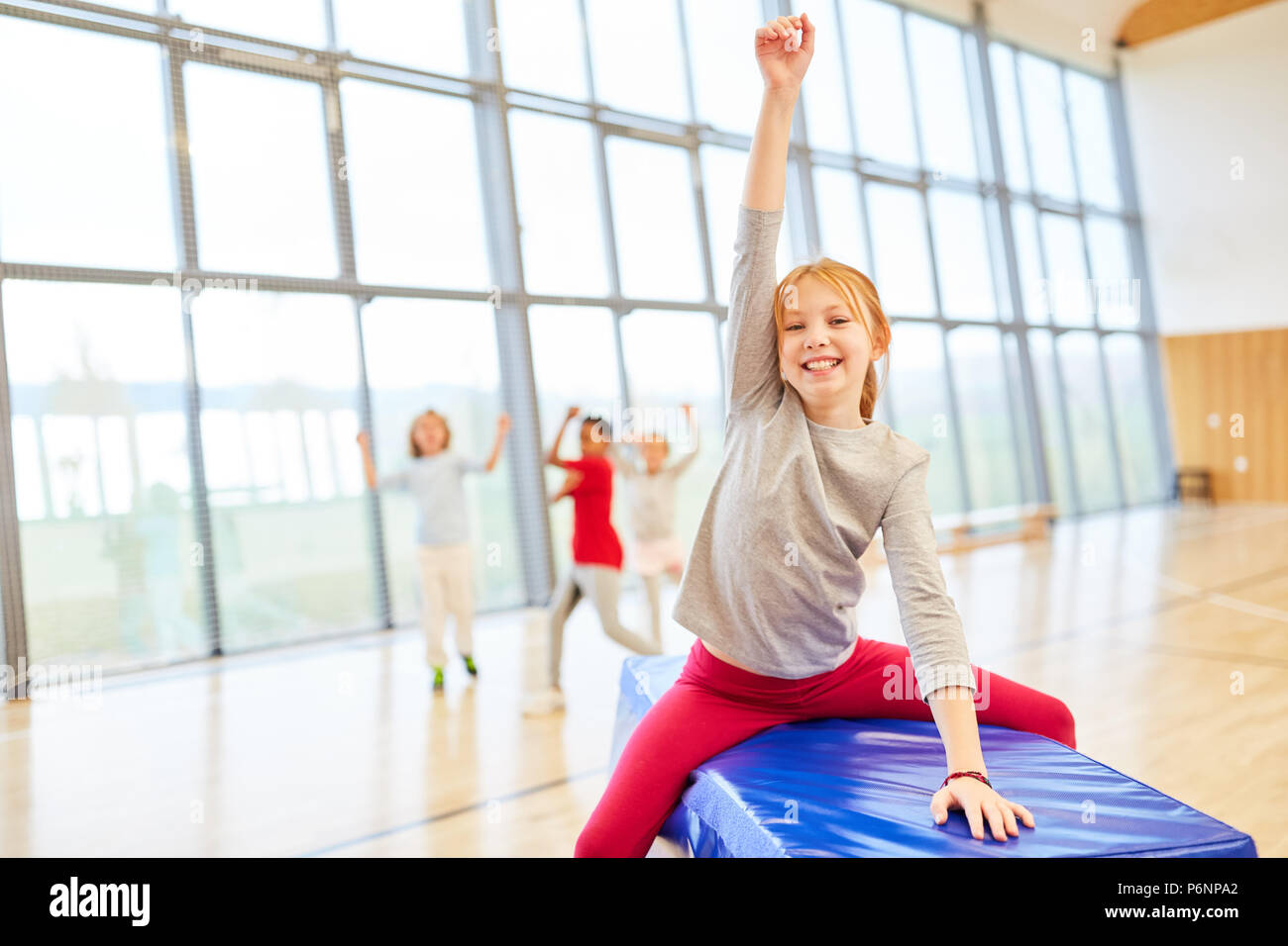 Happy girl exults in physical education in the gym of elementary school Stock Photo