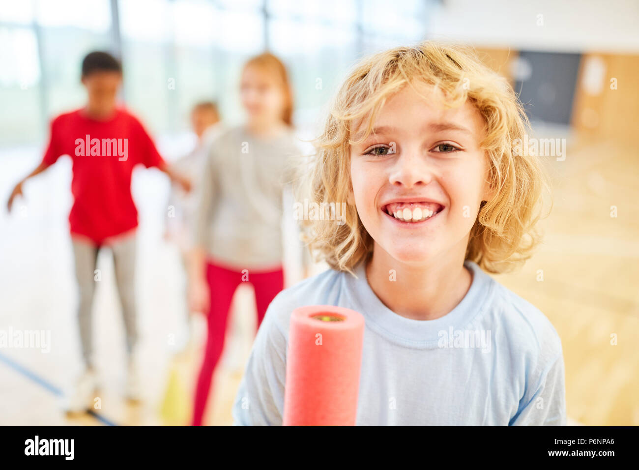 Happy boy with baton in primary school physical education Stock Photo