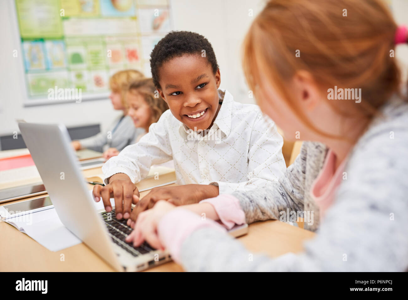 Children learn computer science together at laptop Computer in elementary school Stock Photo