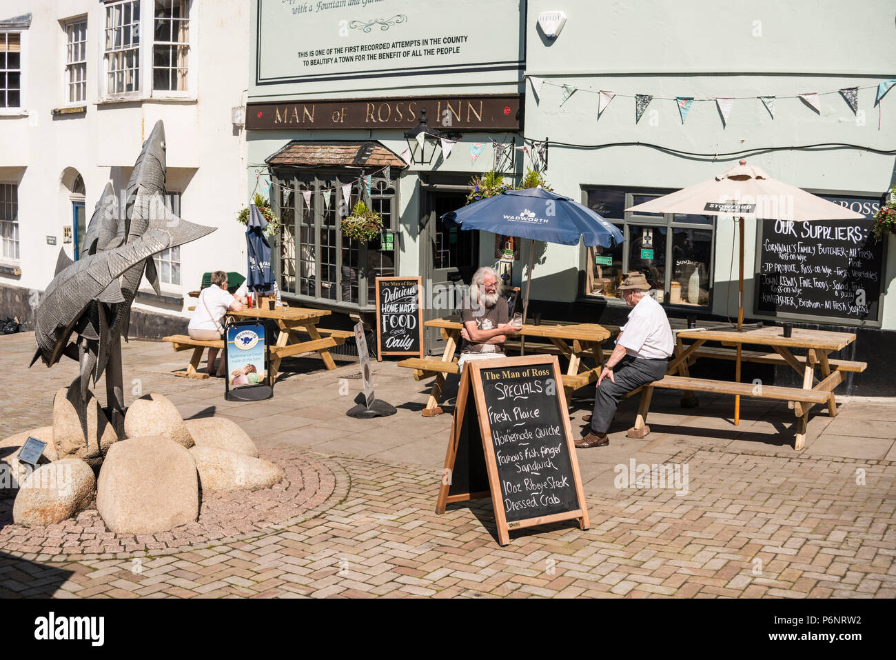 People sitting outside of Man of Ross Inn pub and enjoying drinks and sunny weather, Wye Street, The Man of Ross Inn, Ross on Wye, Herefordshire, UK Stock Photo