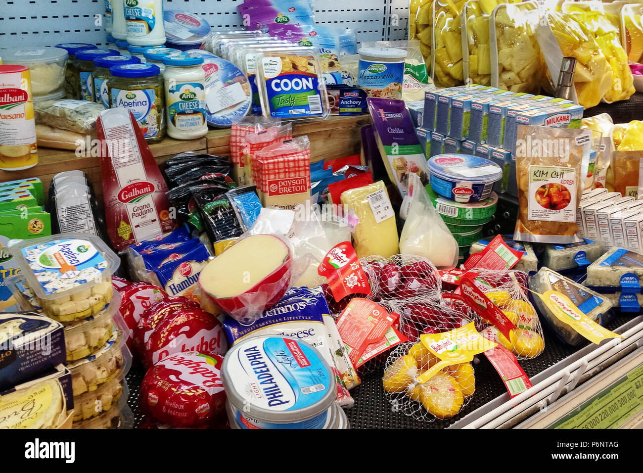 Bali, Jimbaran, 2018-04-28: Shelf in grocery store with huge selection of various delicacies cheeses in different packages, shapes, types. Stock Photo