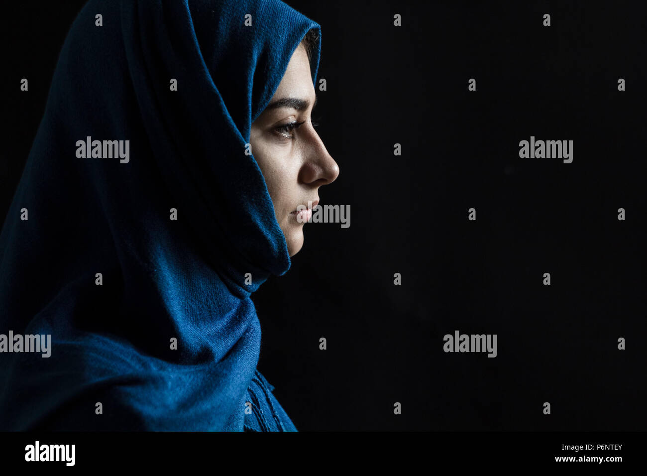 Muslim beautiful girl in hijab. Portrait of an arab young woman on a black background. Stock Photo