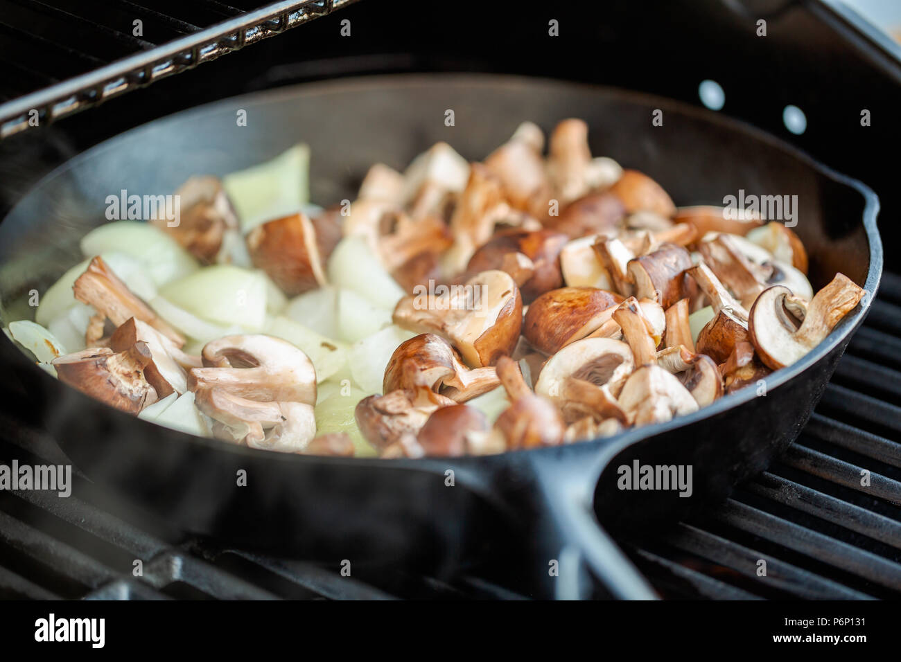 Step by step. Grilled mushrooms and onions in cast iron frying pan on