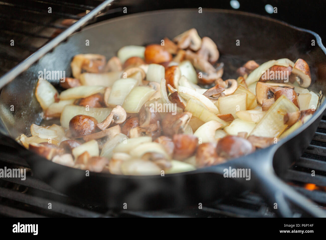 Step by step. Grilled mushrooms and onions in cast iron frying pan on