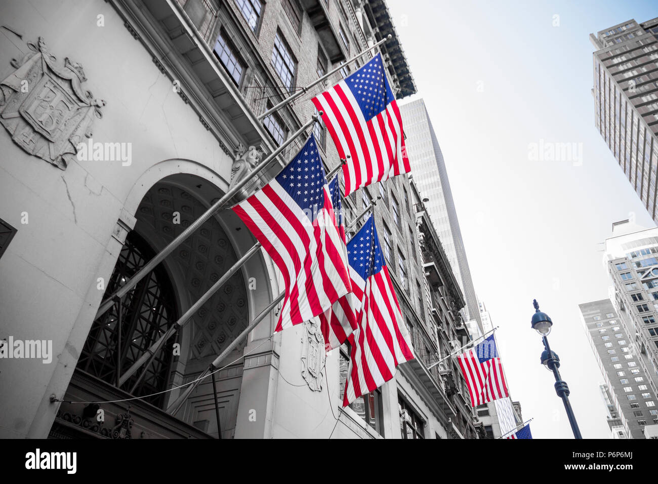 New York City, United States. Multiple American flags waving from the facade of a building Stock Photo