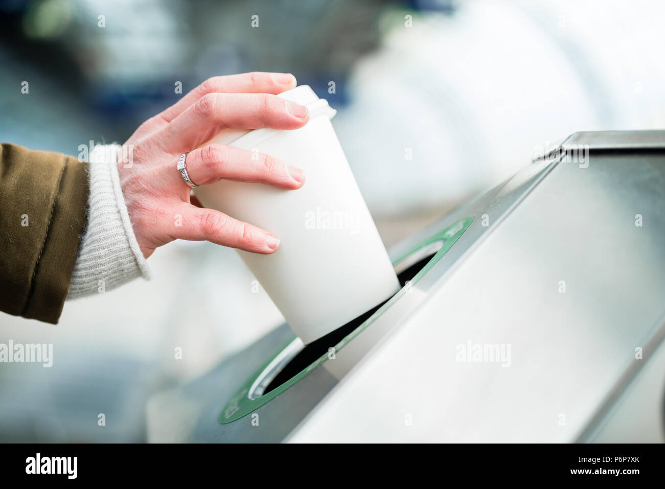 Woman using waste separation container throwing away coffee cup Stock