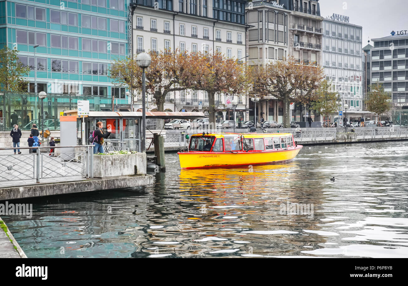Geneva, Switzerland - November 26, 2016: Passengers loading on boat near bridge Mont-Blanc. Mouettes are small yellow water taxis on Geneva lake Stock Photo