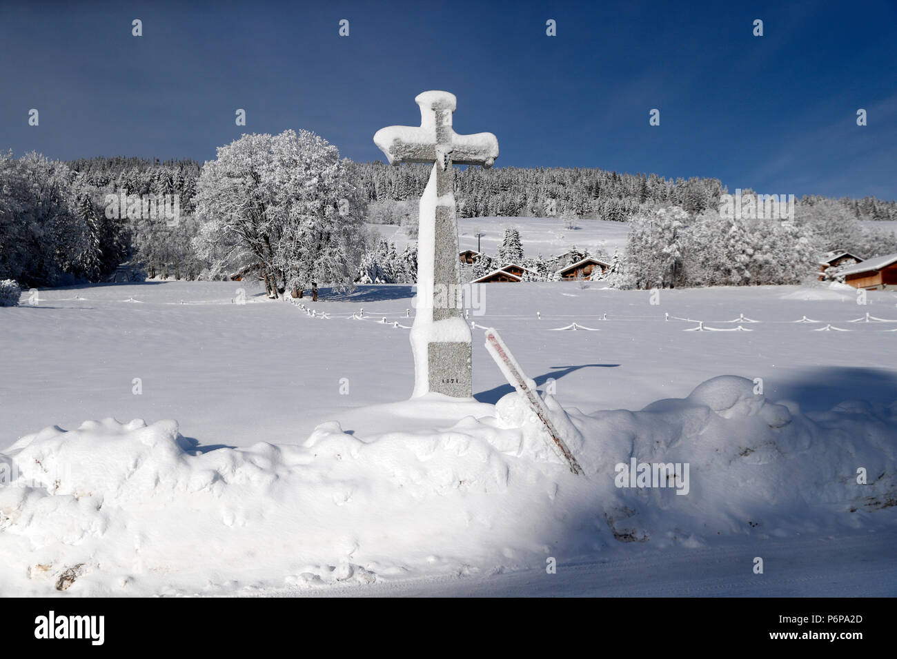 Stone cross with snow in winter.  Megeve. France. Stock Photo