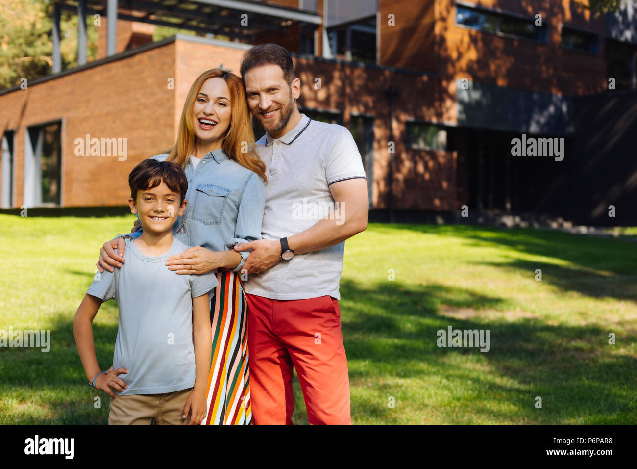 Gleeful parents standing with their son Stock Photo