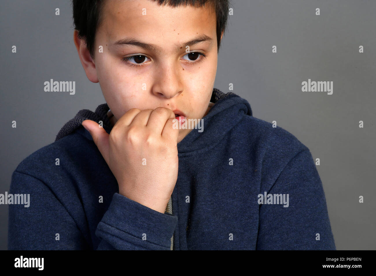 12-year-old boy biting his nails. Paris, France. Stock Photo
