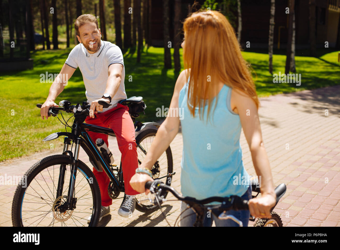 Happy man riding a bike with his wife Stock Photo