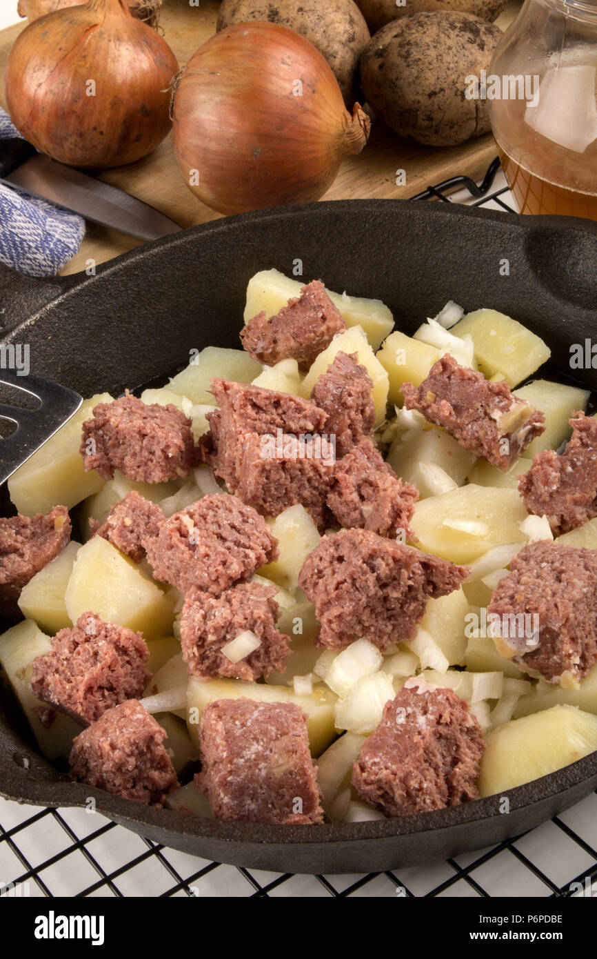 very irish meal, raw corned beef hash in a cast iron pan Stock Photo