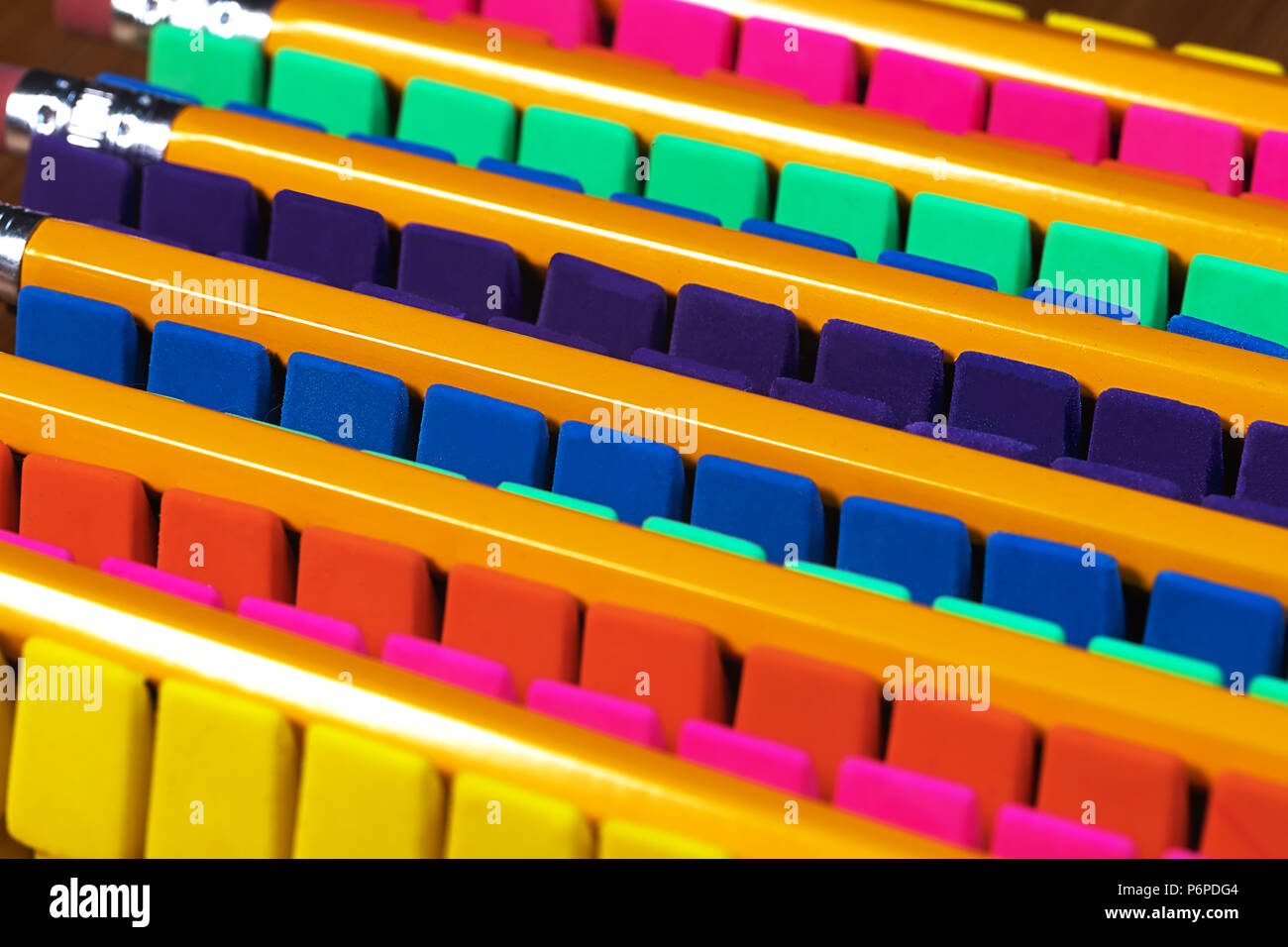 Rows of brightly colored pencil erasers lined up in an OCD orderly fashion, with pencils laying