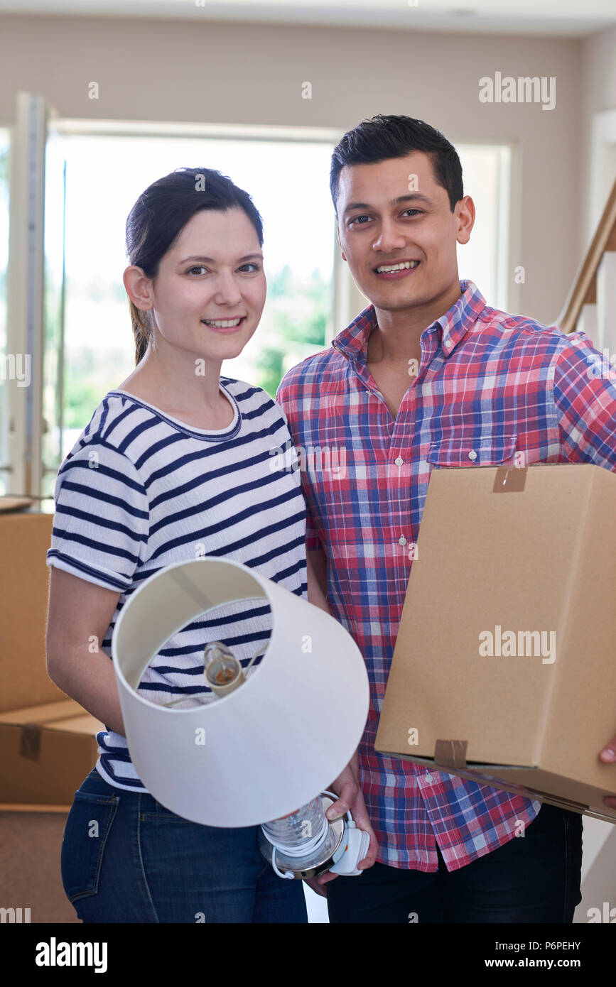 Portrait Of Couple Carrying Boxes Into New Home On Moving Day Stock ...