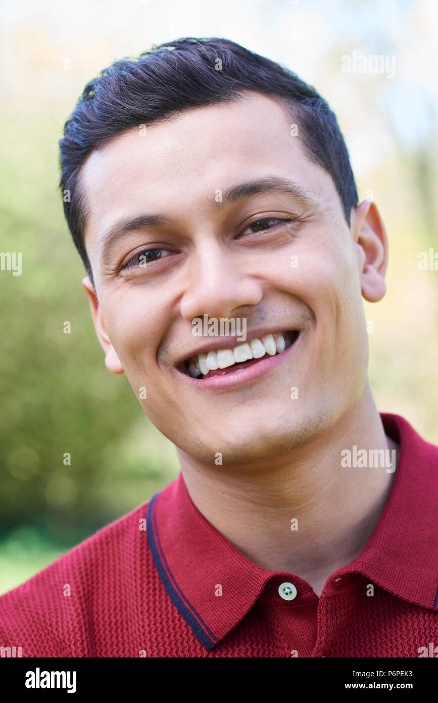 Outdoor Head And Shoulders Portrait Of Smiling Young Man Stock Photo